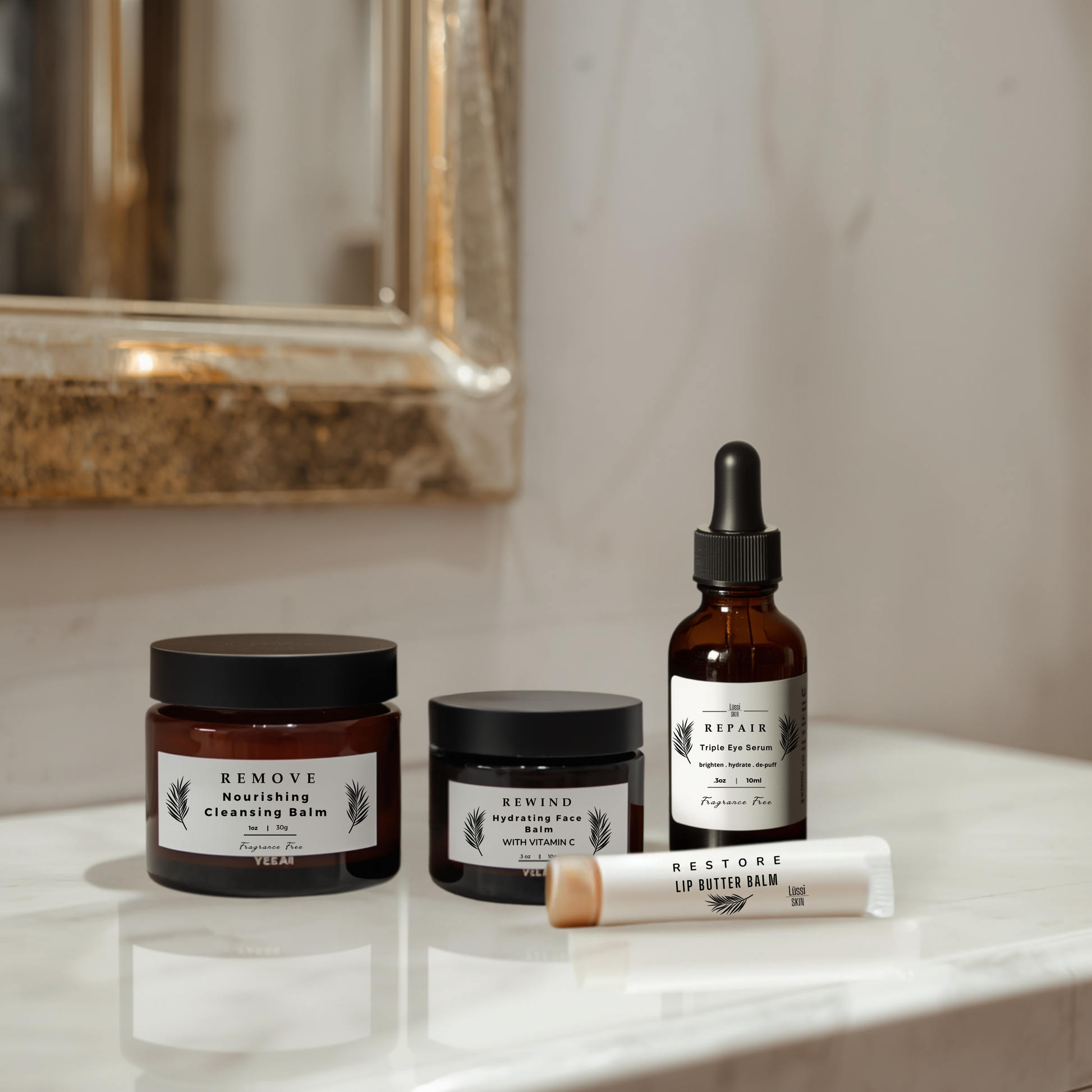 Skin Recovery Set on a bathroom counter with a mirror in the background. Eye serum, Lip Butter Balm, Vitamin C Turmeric Face Balm, Cleansing Face Balm