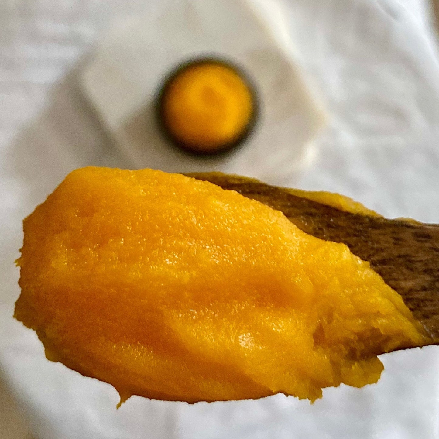 A close up of a rich, orange face balm of turmeric and vitamin C.
